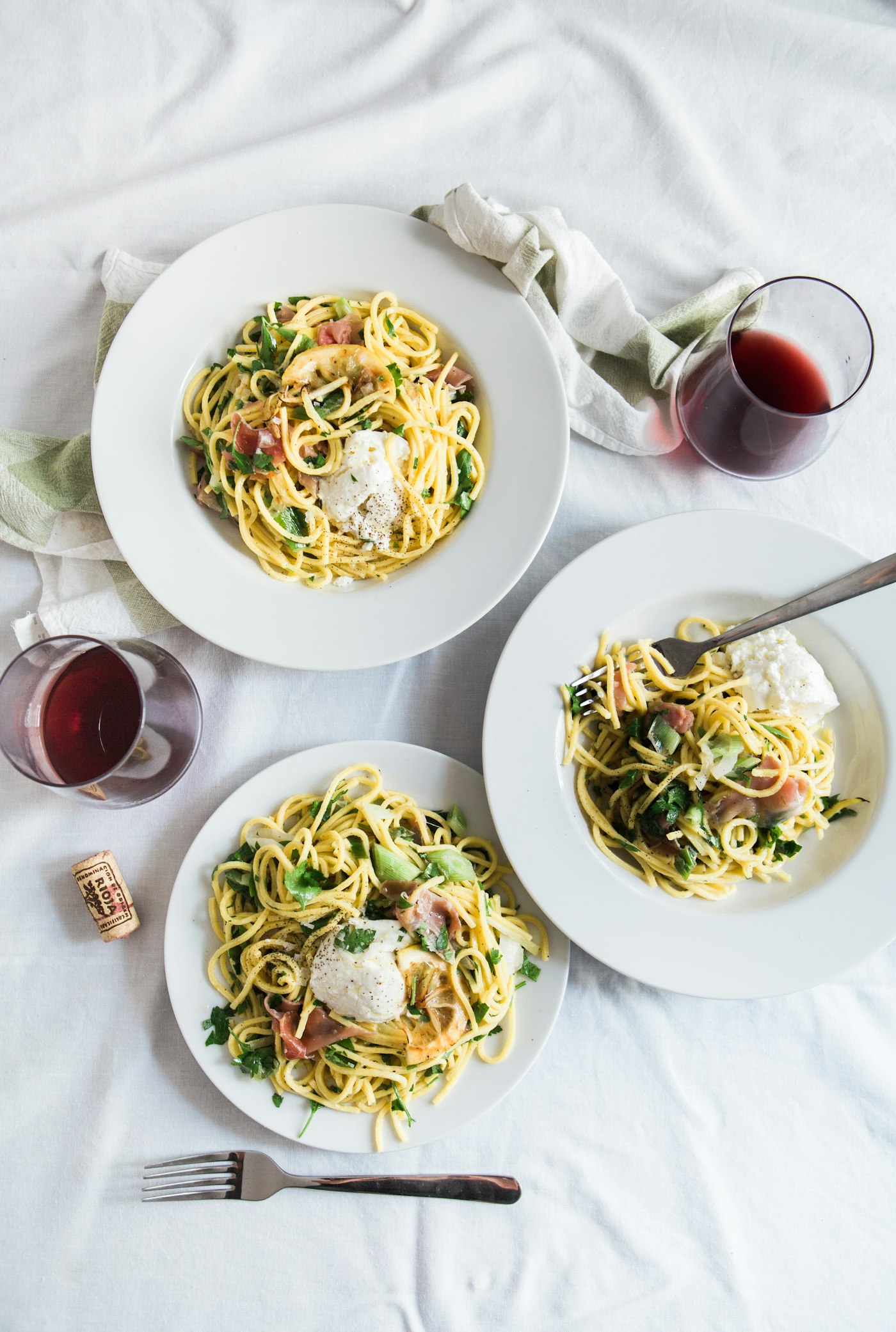 A plated pasta with a glass of red wine